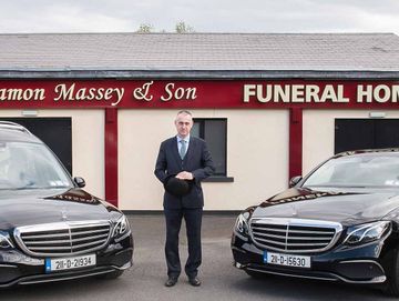 A funeral director standing outside the Ramon Massey & Son outside the funeral home