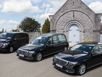 Ramon Massey & Son's hearses outside a church