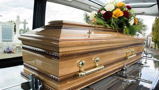 A wooden coffin inside a hearse