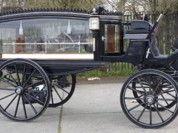 A parked black horse drawn carriage