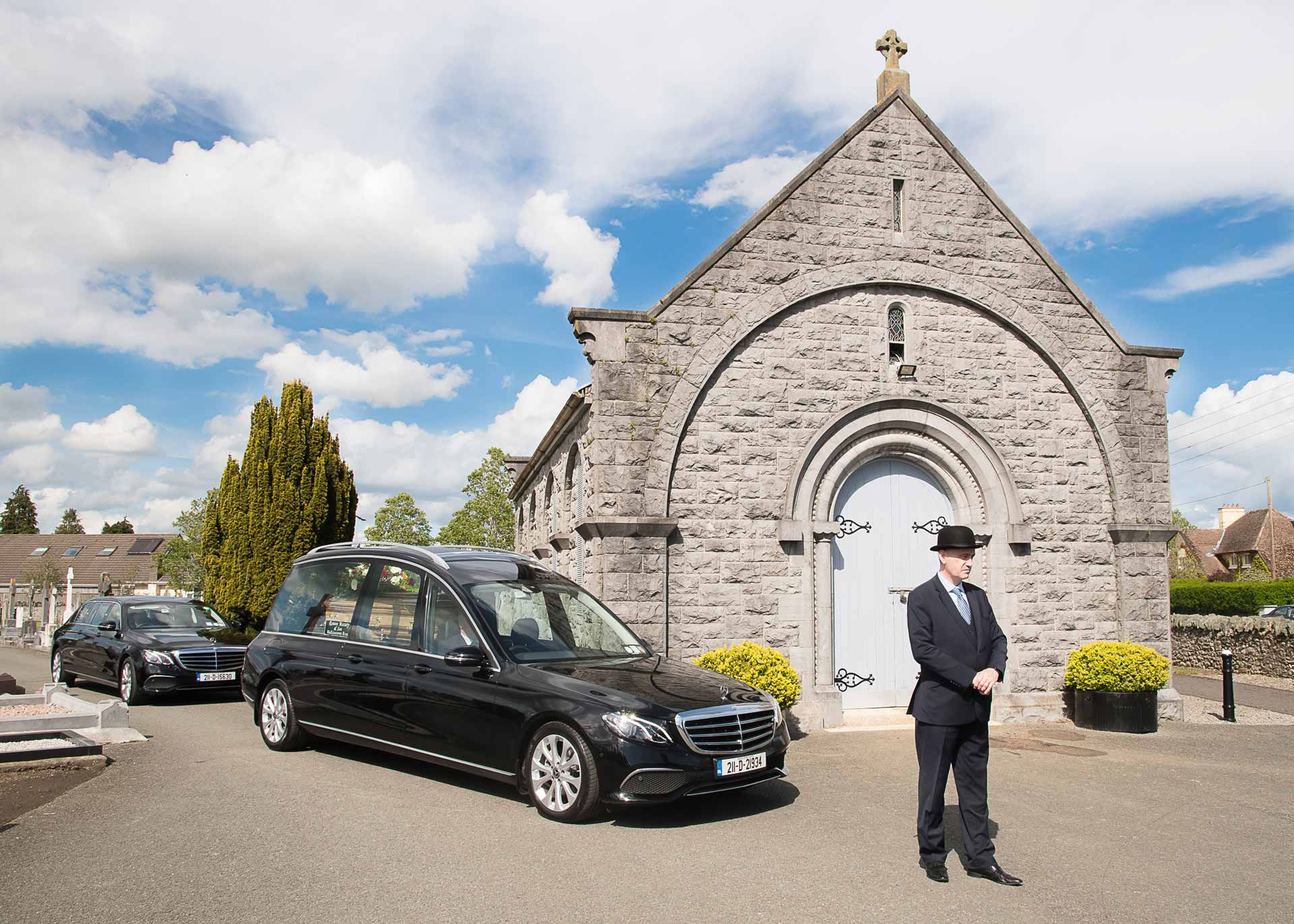 A Massey Ramon & Son funeral director leading a funeral procession
