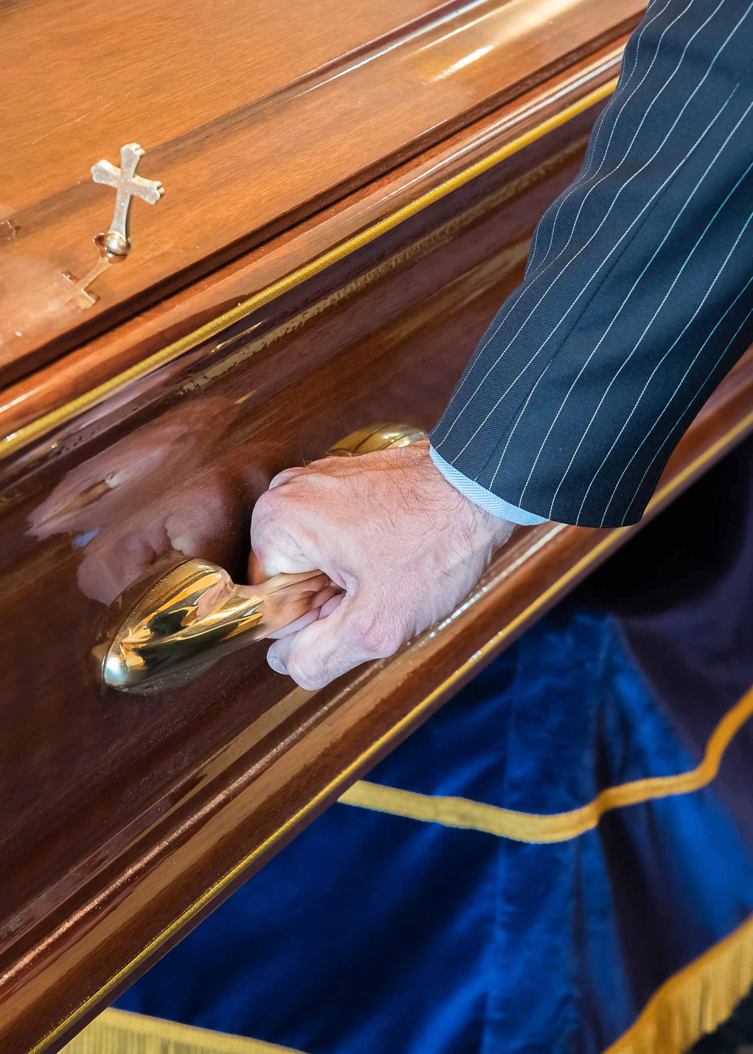 Close up of a coffin with gold handles